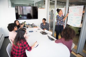 Employees working around table in room