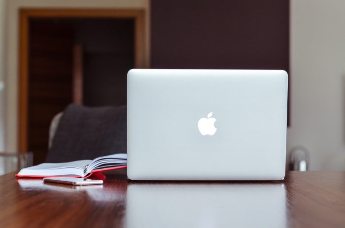 Apple Laptop on Desk with Notebooks