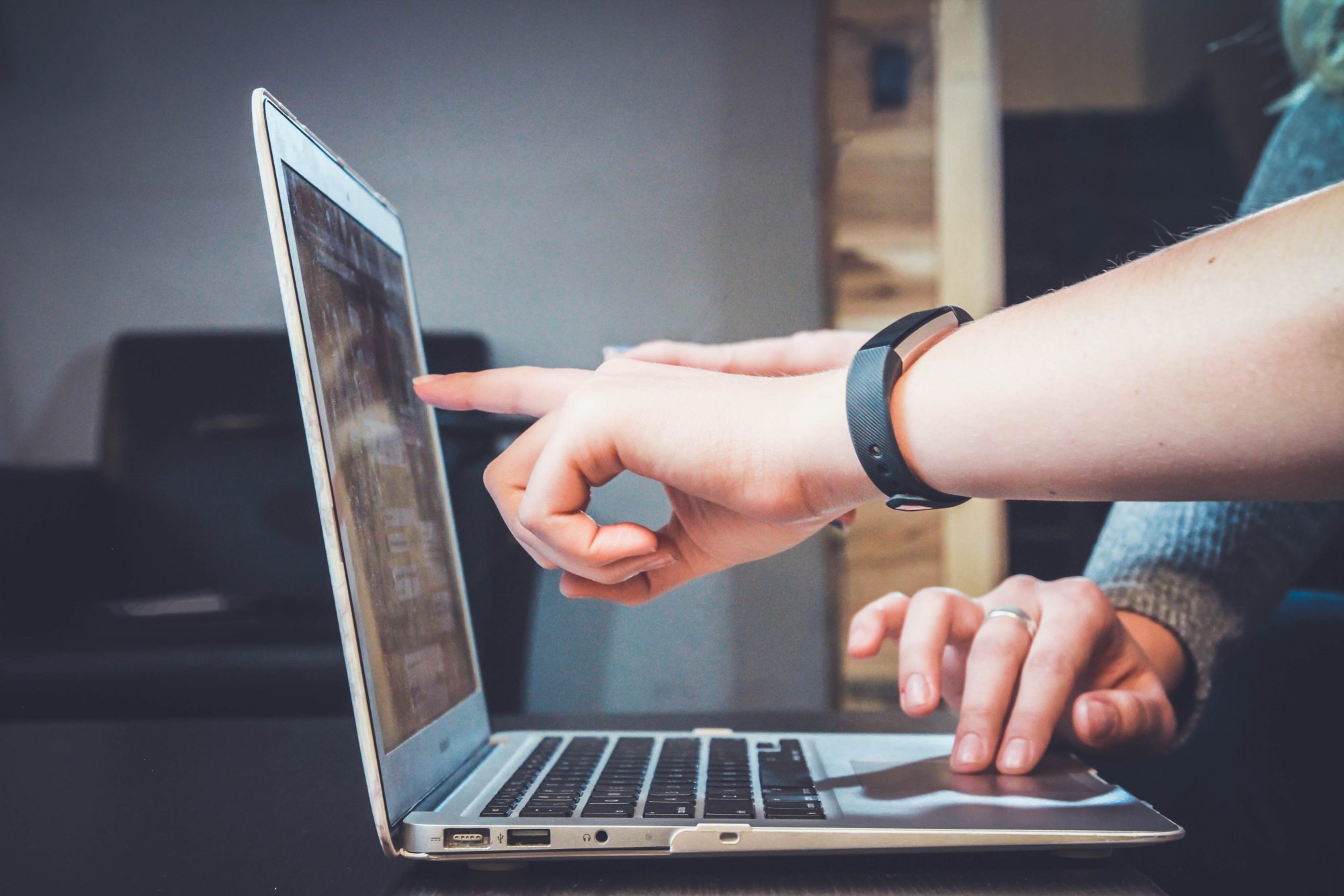 Hand pointing at a laptop 