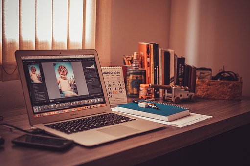 A laptop and a notebook on a wooden table