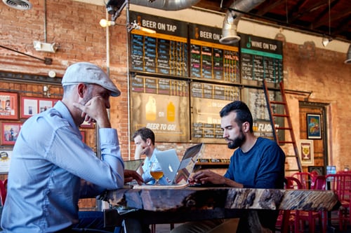 people sitting in a cafe using their laptops