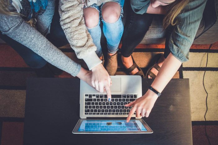 2 People pointing at a laptop screen