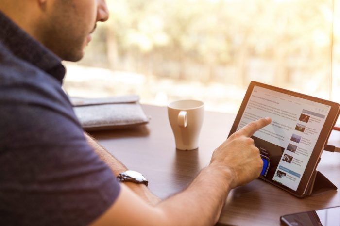 A man touching an iPad