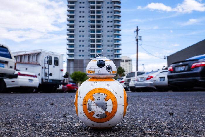 A white and orange robot on the ground 