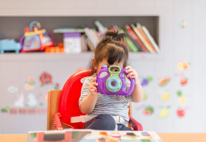 A little girl playing with a purple toy