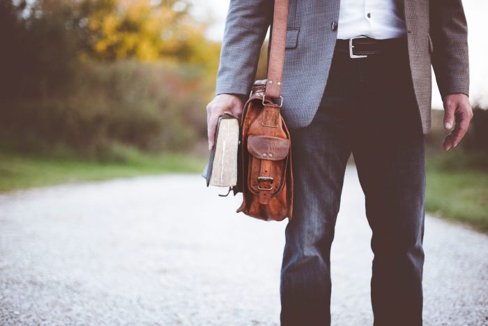 Man holding brief case and book 