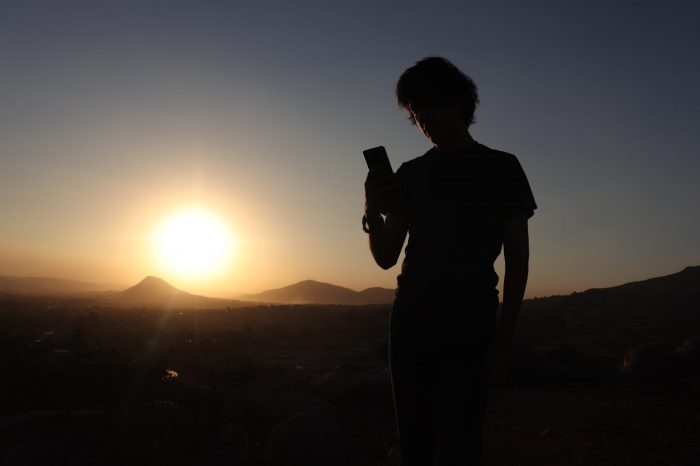 Man standing in a shadow with a phone