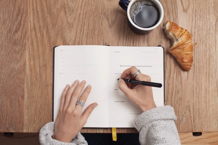 Hands writing in a note pad