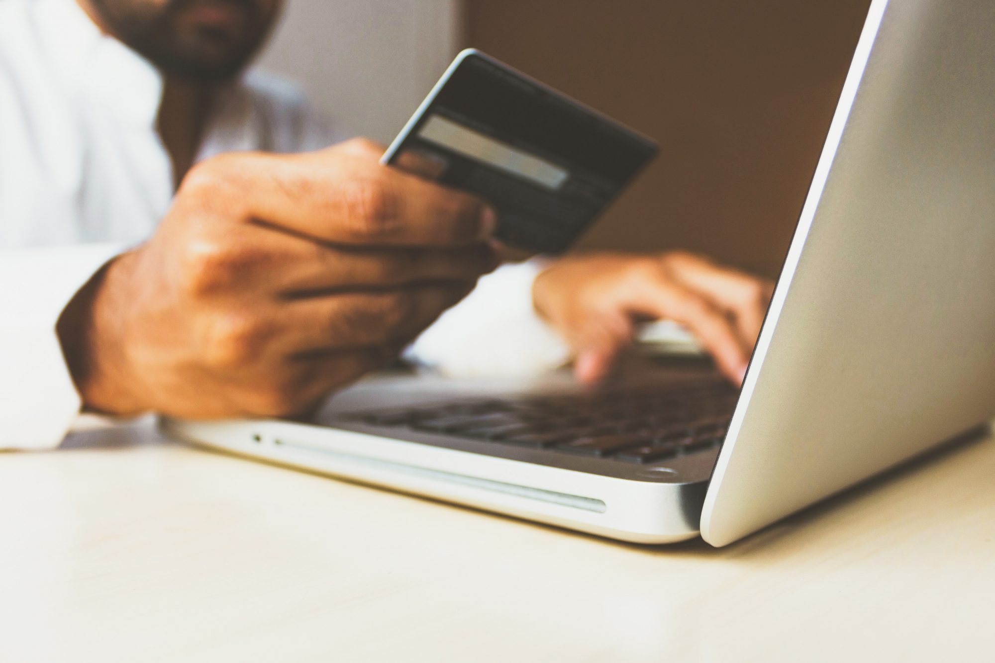 Man holding credit card and typing on computer