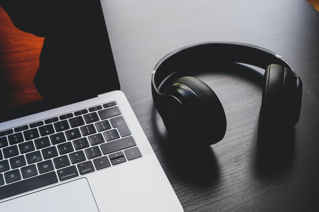 Black headphones next to a laptop