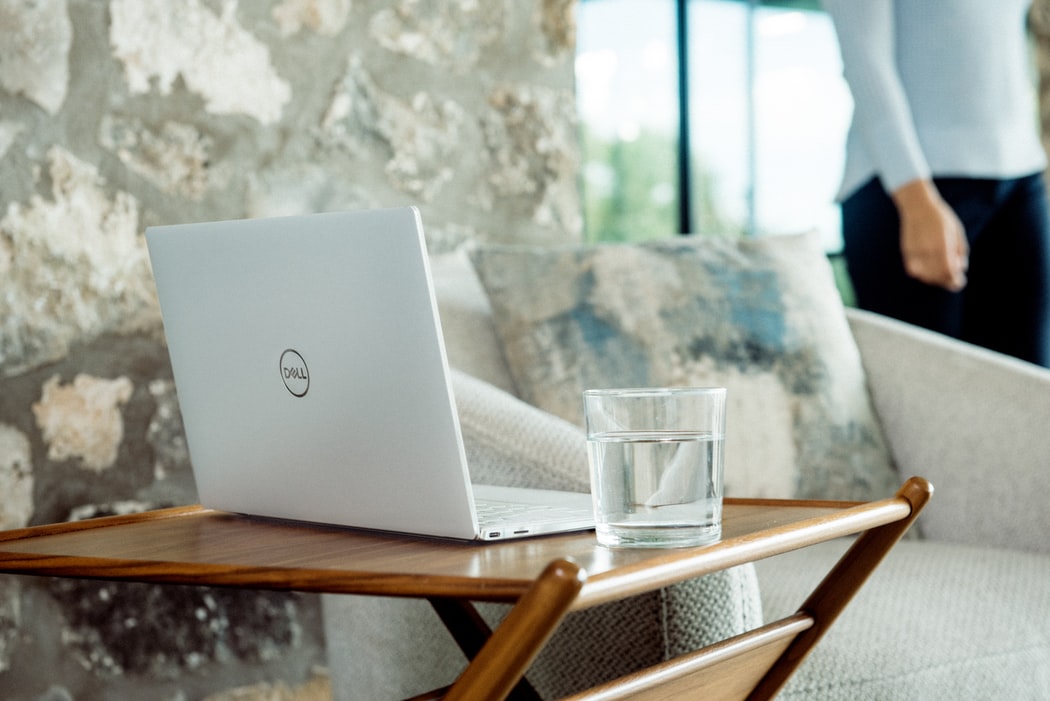 A laptop with a water glass