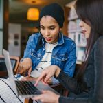 two women looking at a laptop