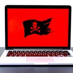 A red laptop screen with a pirate logo