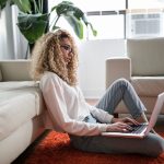 Girl leaning on couch while on laptop